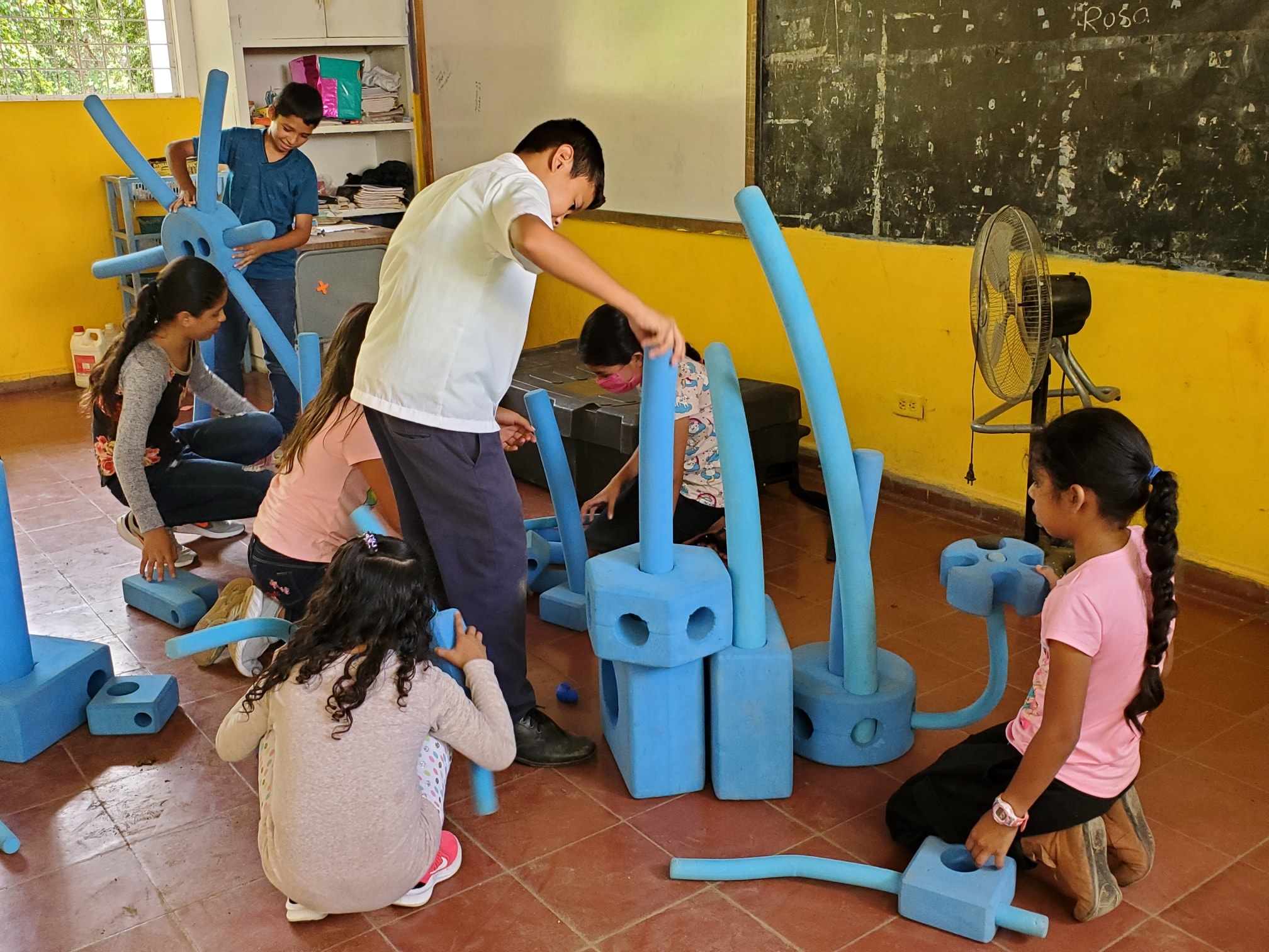 Niños haciendo una dinámica en un taller ofrecido por UNODC.