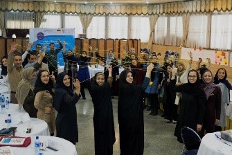 Women in Hijabs in a workshop room holding up strings of thread