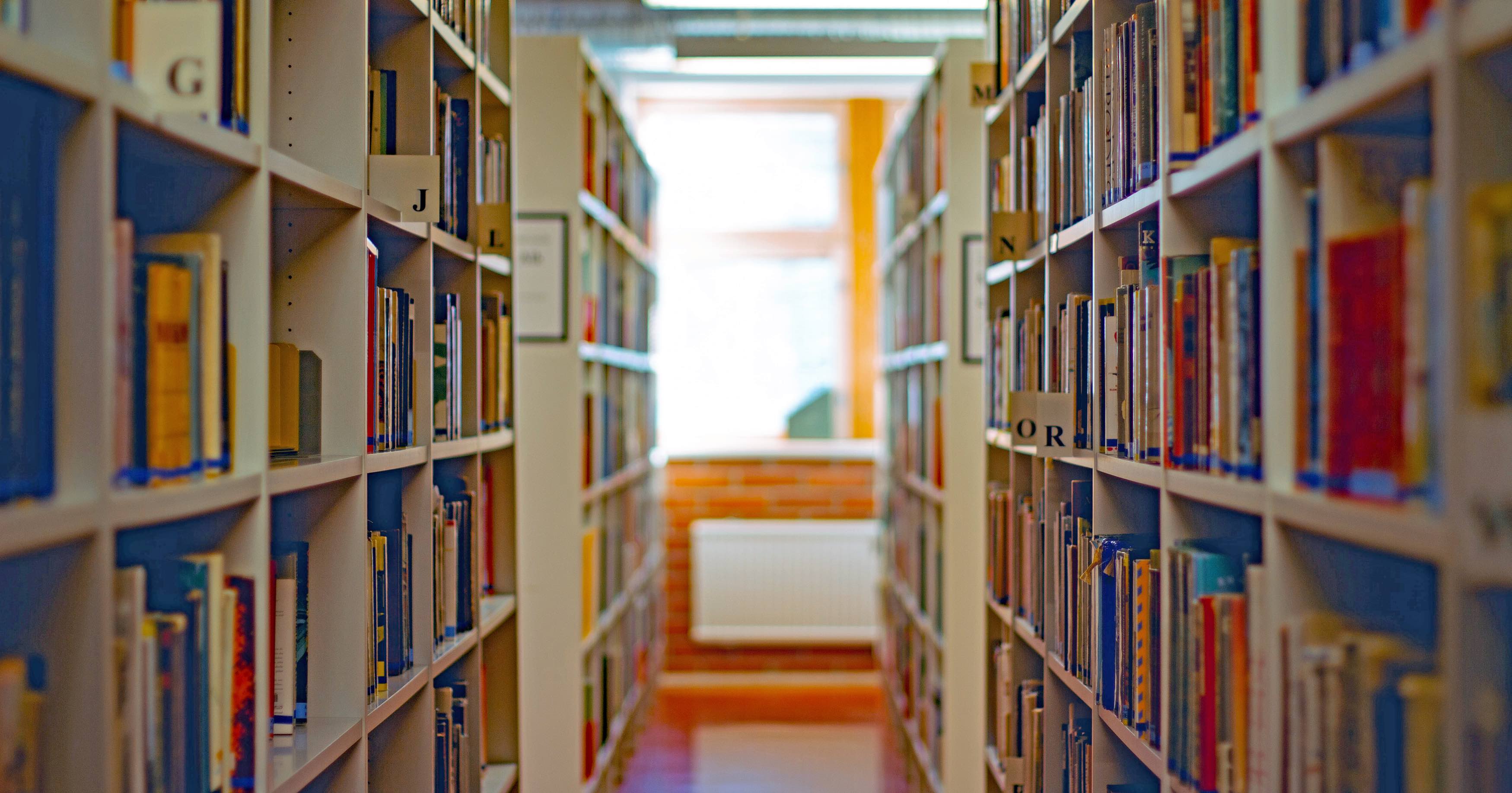 Image of a library with bookshelves seen on the left- and right-hand side. 