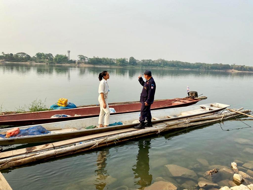 Suchaya Mokkhasen discussing cross-border challenges with a representative from a village security unit on the Mekong River in Nong Khai Thailand